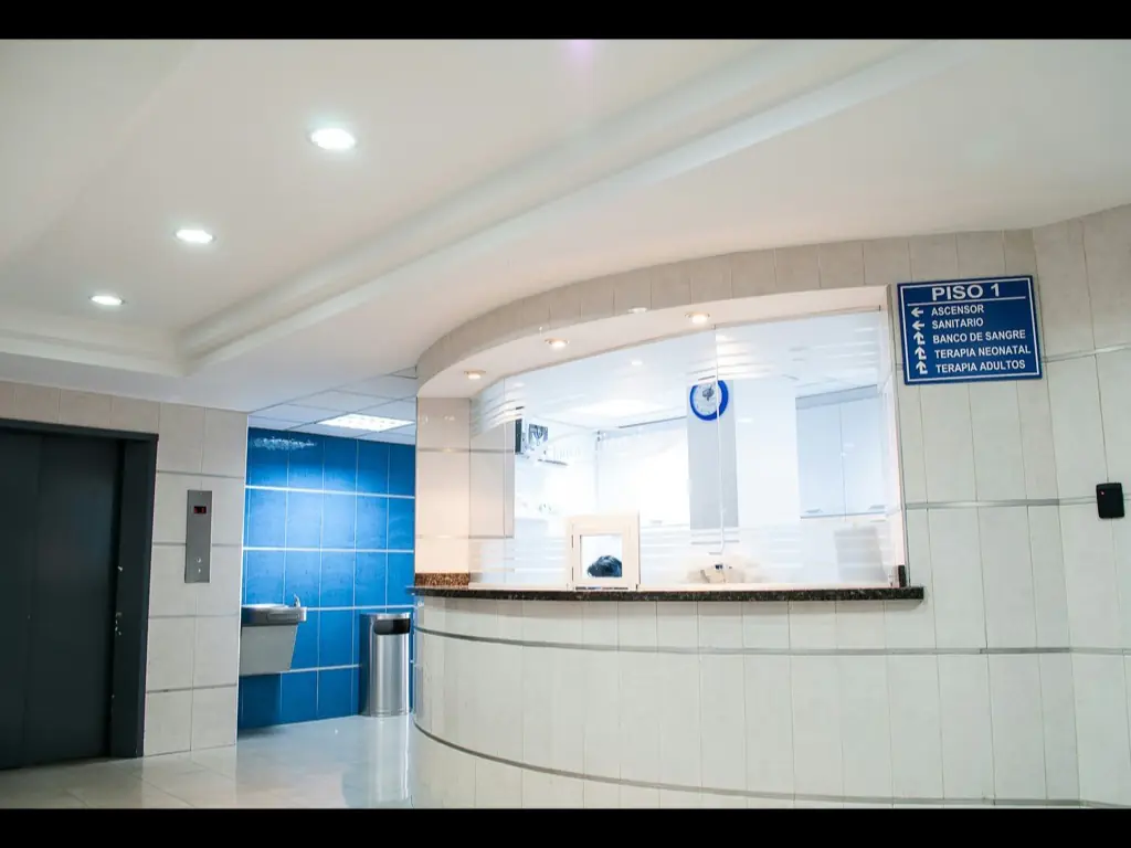 A bright, empty clinic reception desk under even ceiling lighting.
